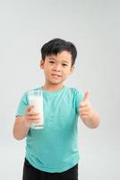 A drinking milk boy is showing his thumb up isolated on the white background photo