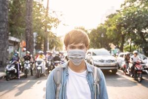 Tourist man with mask having a coffee while walking on street, travel concept in the new normal photo