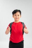 Happy young asian school boy with thumbs up isolated on a white background. photo