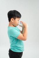 Adorable little boy with glass of milk on white background photo