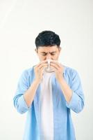 Young asian man sneezing after get allergy or flu virus and using tissue paper for swipe on nose at medical clinic after got coronavirus codisease for unhealthy lifestyle concept photo