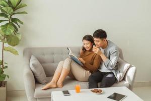 Beautiful loving couple reading a book on the sofa photo