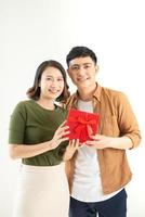 Portrait of happy couple in casual wear standing, holding box with present and looking at camera together photo