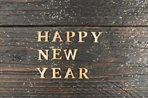 Happy New Year Letters on wooden postcard on wooden background.c opyspace for text photo