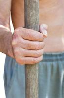 peasant holds old wooden tool handle photo