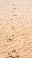 Footprints on the sand of dune in Wadi Rum desert photo