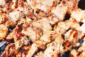 pieces of shish kebabs on skewers on brazier photo