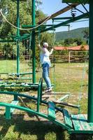 girl overcomes an outdoor obstacle course photo