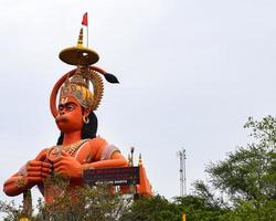 New Delhi, India - June 21, 2022 - Big statue of Lord Hanuman near the delhi metro bridge situated near Karol Bagh, Delhi, India, Lord Hanuman statue touching sky photo