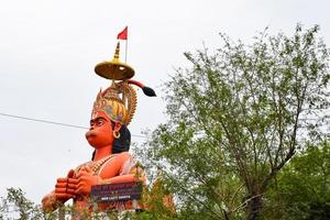 New Delhi, India - June 21, 2022 - Big statue of Lord Hanuman near the delhi metro bridge situated near Karol Bagh, Delhi, India, Lord Hanuman statue touching sky photo