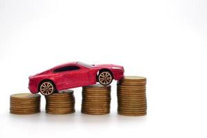 Small red car model on a large amount of stacked coins. Economy and business concept. photo