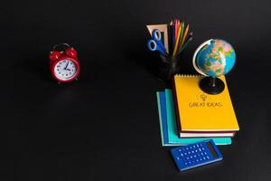 Some educational school supplies on a black background. photo