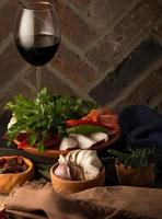 A vertical shot of appetizers and a glass of wine photo