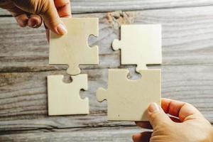 White jigsaw puzzle connecting together. Team business success partnership or teamwork concept. A group of business people assembling jigsaw puzzle. Business solutions, success and strategy concept. photo