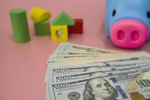 Hand of the kids take a wood block with small  house models on top of block.Concept of saving money for future , investment property and saving money to buy a house. On blur background. photo