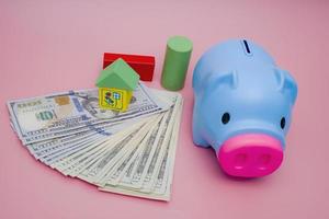 Hand of the kids take a wood block with small  house models on top of block.Concept of saving money for future , investment property and saving money to buy a house. On blur background. photo