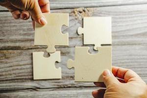 White jigsaw puzzle connecting together. Team business success partnership or teamwork concept. A group of business people assembling jigsaw puzzle. Business solutions, success and strategy concept. photo