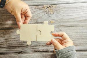 White jigsaw puzzle connecting together. Team business success partnership or teamwork concept. A group of business people assembling jigsaw puzzle. Business solutions, success and strategy concept. photo