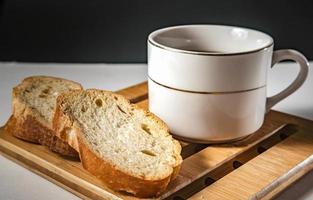 bread for breakfast, with cup of coffee over rustic wooden background with copy space. Morning breakfast with coffee and toasts.