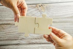 White jigsaw puzzle connecting together. Team business success partnership or teamwork concept. A group of business people assembling jigsaw puzzle. Business solutions, success and strategy concept. photo