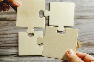 White jigsaw puzzle connecting together. Team business success partnership or teamwork concept. A group of business people assembling jigsaw puzzle. Business solutions, success and strategy concept. photo