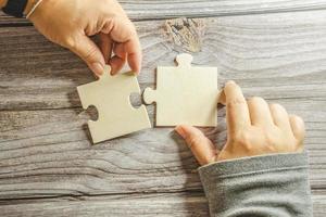 White jigsaw puzzle connecting together. Team business success partnership or teamwork concept. A group of business people assembling jigsaw puzzle. Business solutions, success and strategy concept. photo