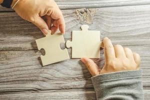 White jigsaw puzzle connecting together. Team business success partnership or teamwork concept. A group of business people assembling jigsaw puzzle. Business solutions, success and strategy concept. photo