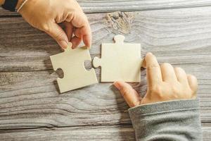 White jigsaw puzzle connecting together. Team business success partnership or teamwork concept. A group of business people assembling jigsaw puzzle. Business solutions, success and strategy concept. photo