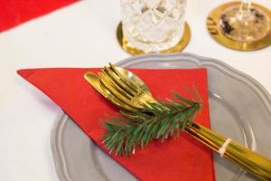 Christmas plate and goldware with red cloth with branch of fir tree photo