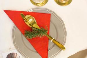 Christmas plate and goldware with red cloth with branch of fir tree photo