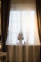 Abstract and blurry image of window with curtains with fir tree photo