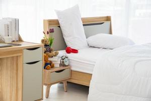 el diseño interior moderno o minimalista de la habitación está decorado con una cómoda cama doble, ropa de cama blanca como mantas, almohadas y muebles de madera foto