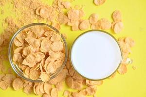 desayuno matutino cereal integral fresco, copos de maíz con leche sobre fondo amarillo, tazón de copos de maíz comida para el desayuno y merienda para un concepto de comida saludable foto