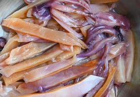 raw squid for cooking food on wooden table, preserving food seafood, pickled squid on bowl photo