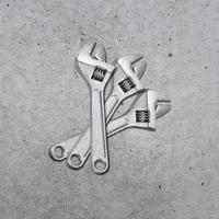 metal adjustable wrenches on a cement background, top view photo