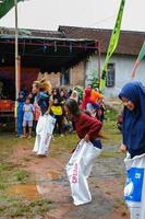 blitar, indonesia - 11 de septiembre de 2022. los participantes del saco compiten en el campo y la audiencia apoya juntos cuando este evento conmemora la celebración del día de la independencia de indonesia en blitar foto