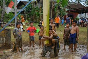 blitar, indonesia - 11 de septiembre de 2022. algunos niños están listos para participar en una competencia de escalada de árboles de plátano para conmemorar la independencia de indonesia en blitar foto