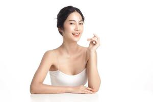 Asian woman with a beautiful face and Perfect clean fresh skin. Cute female model with natural makeup and sparkling eyes on white isolated background. Facial treatment, Cosmetology, beauty Concept. photo