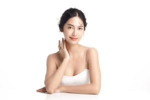 Asian woman with a beautiful face and Perfect clean fresh skin. Cute female model with natural makeup and sparkling eyes on white isolated background. Facial treatment, Cosmetology, beauty Concept. photo