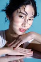 atractiva joven modelo de mujer asiática de cabello mojado con piel fresca perfecta en simulación submarina de iluminación cuidado facial tratamiento facial cosmetología cirugía plástica retrato de niña encantadora en estudio