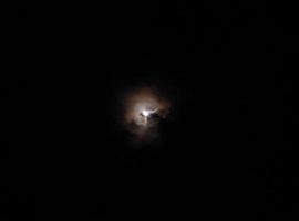 Moon in the clouds in the night sky photo