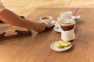 el camarero sirve café en la cafetería en la mesa al aire libre. foto