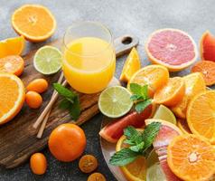 Glass of juice and citrus fruits photo