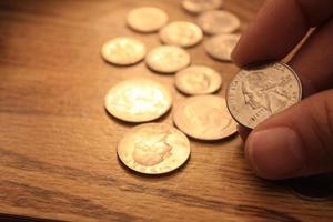 Las monedas de diez centavos y los cuartos de monedas son la moneda de América. en manos de los hombres. foto