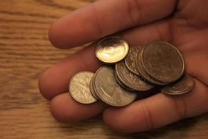 Quarters and Dime coins are the currency of America. In the hands of men. photo