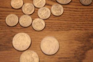 cuartos y monedas de diez centavos son la moneda de América. extiéndelas en el piso de madera. foto