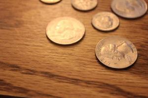 Quarters and Dime coins are the currency of America. Spread them on the wooden floor. photo