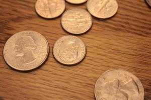 cuartos y monedas de diez centavos son la moneda de América. extiéndelas en el piso de madera. foto