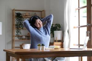 Young attractive asian female   relax cross arm behind head use notebook digital online course program in quarantine at home reskill upskill school class for career path. photo