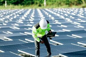 The portrait of a young engineer checks photovoltaic solar panels. Concept. renewable energy technology electricity service, green power. photo